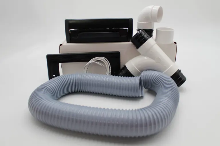 A VacPort install kit laid out: VacPort, trim plate, fittings, installation hose and wire